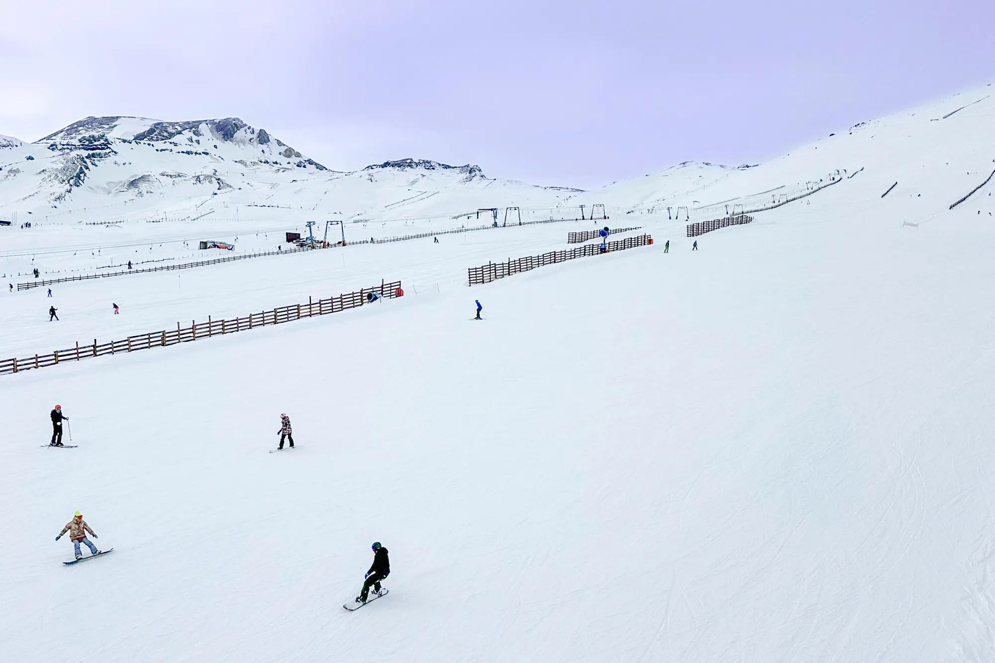 Skiers on snowy slopes at El Colorado Ski Resort, Santiago, with mountain backdrop.