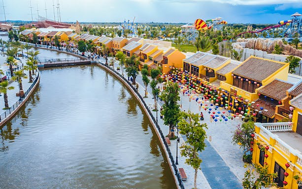 Vinwonders Nam Hoi An Theme Park canal with colorful lanterns and traditional buildings.