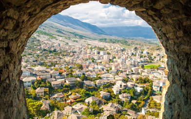 View of Old Town Gjirokaster from the castle, showcasing historic stone houses and surrounding landscape.