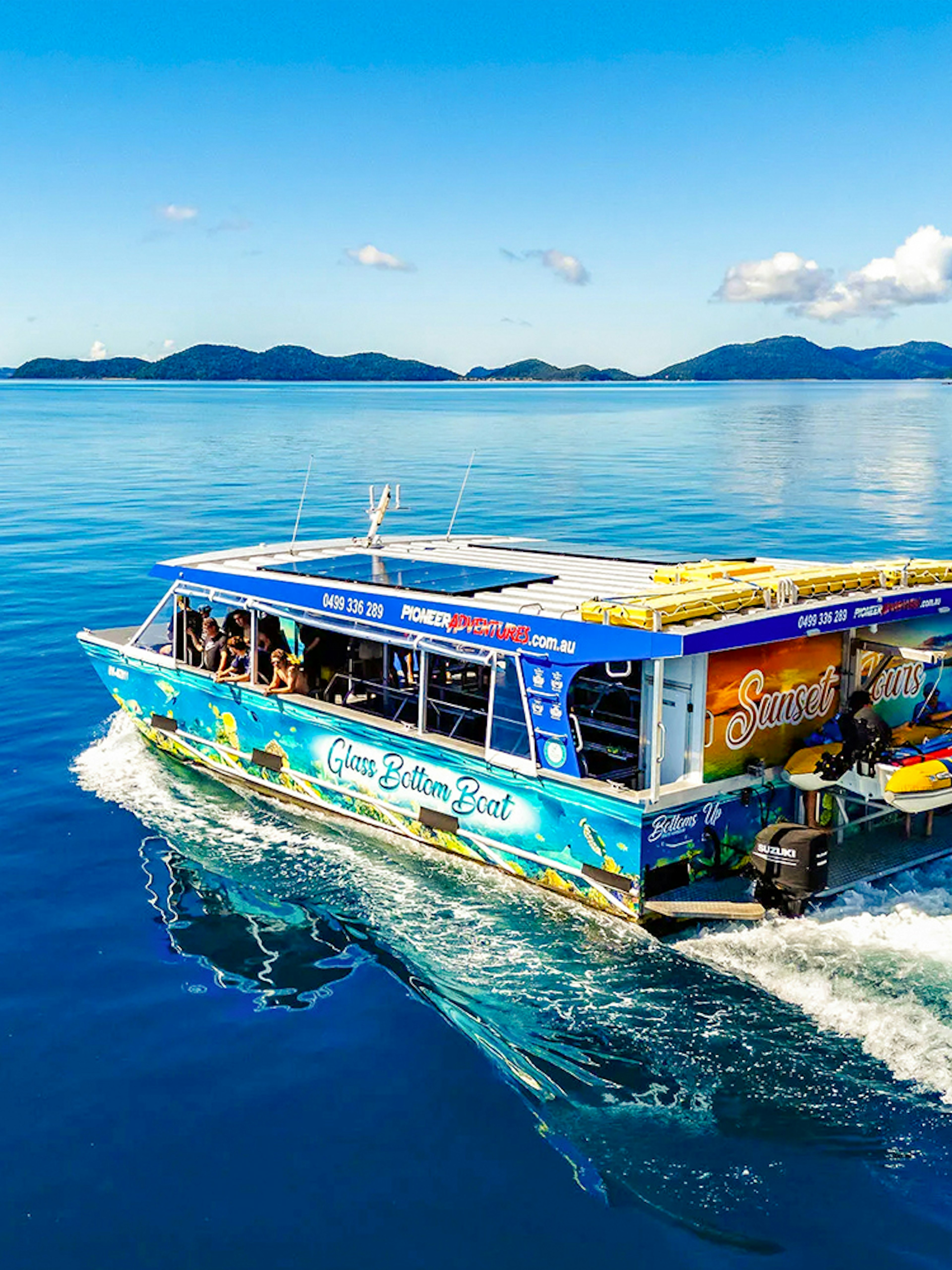 Glass bottom boat cruising near Airlie Beach with scenic island views.
