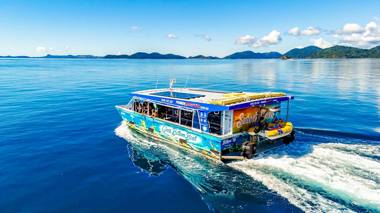 Glass bottom boat cruising near Airlie Beach with scenic island views.