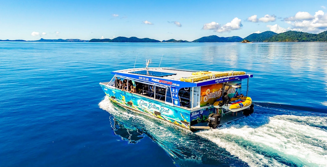 Glass bottom boat cruising near Airlie Beach with scenic island views.