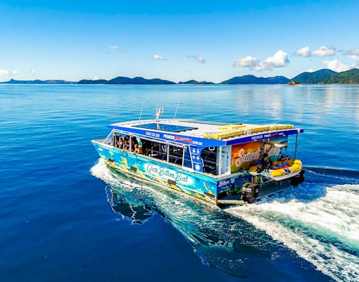 Glass bottom boat cruising near Airlie Beach with scenic island views.
