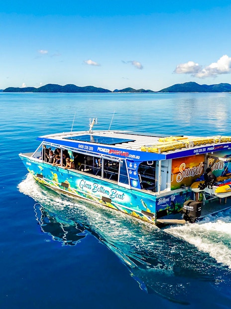 Glass bottom boat cruising near Airlie Beach with scenic island views.