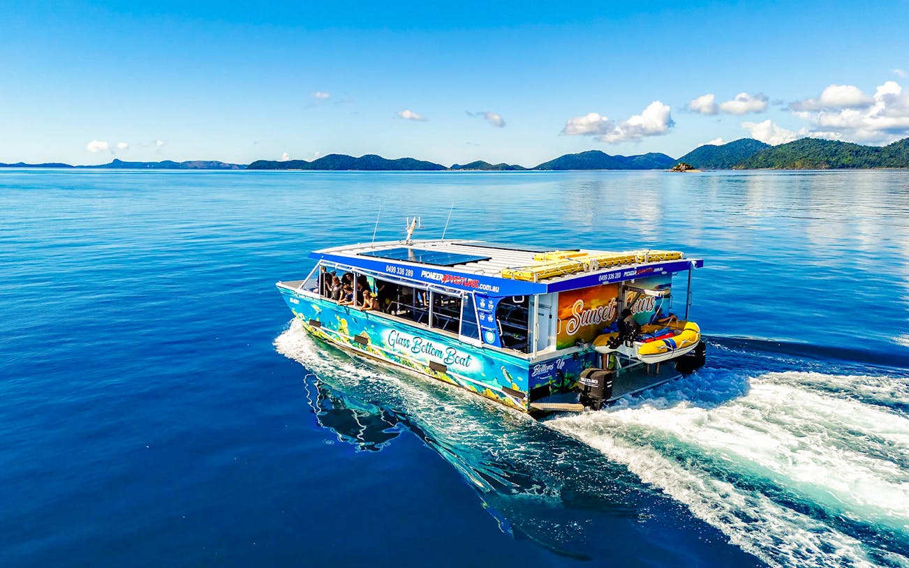Glass bottom boat cruising near Airlie Beach with scenic island views.