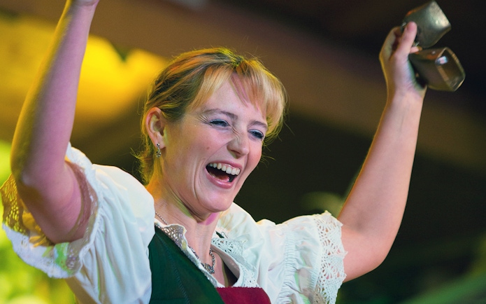 Performer at Tyrolean Evening Folk Show, Austria, holding cowbells.