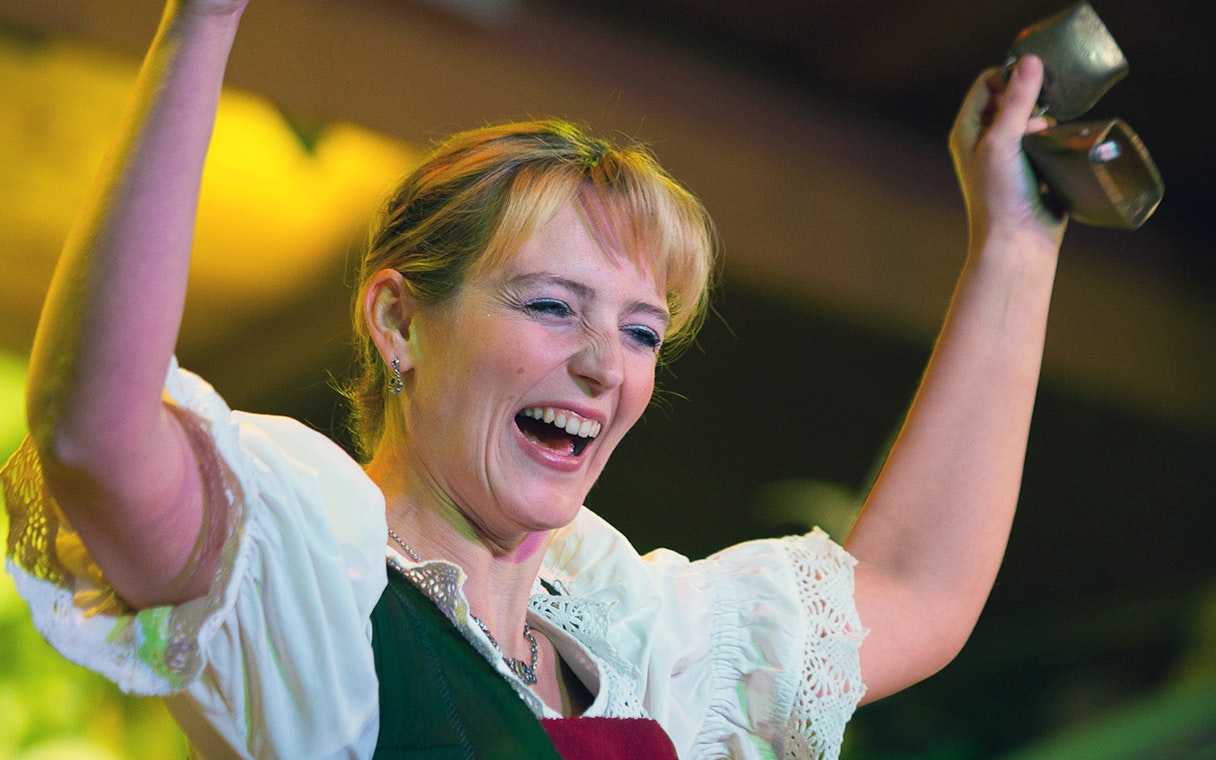 Performer at Tyrolean Evening Folk Show, Austria, holding cowbells.