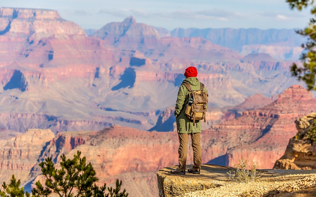 Hiker overlooking the Grand Canyon from the South Rim, Arizona, USA.