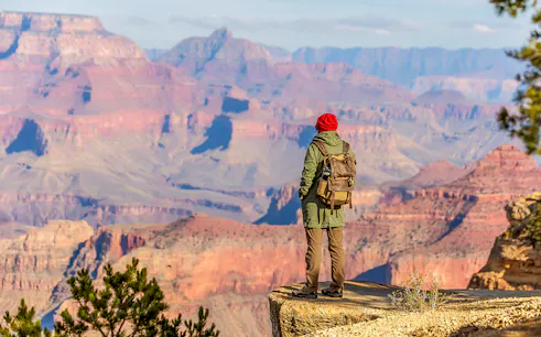 Hiker overlooking the Grand Canyon from the South Rim, Arizona, USA.