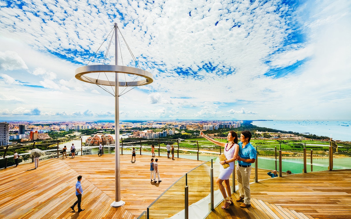 Tourists enjoying the view from Marina Bay Sands SkyPark Observation Deck in Singapore.