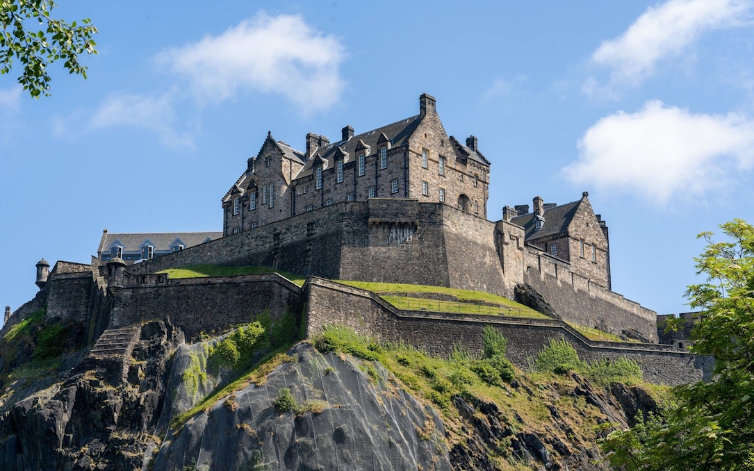 Edinburgh Castle on Castle Rock under a clear blue sky.