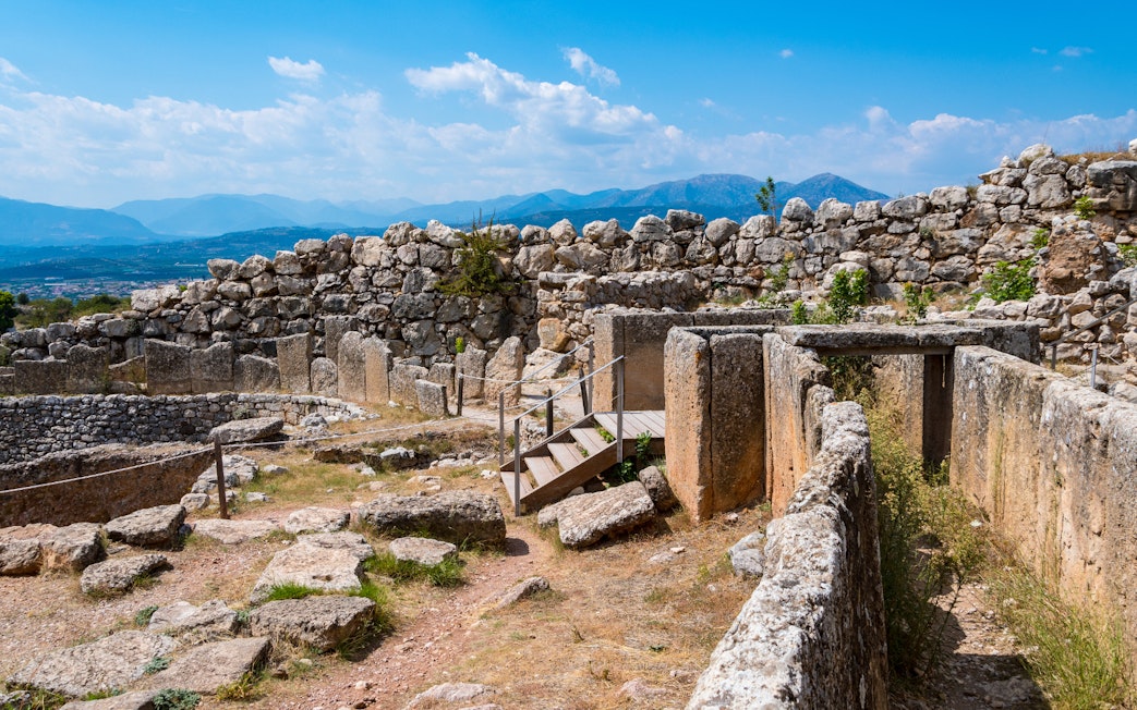 Ancient ruins of Mycenae with stone walls and mountainous backdrop, part of Nafplio-Mycenae-Epidaurus tour.