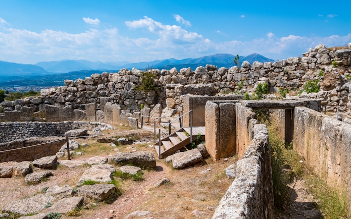 Ancient ruins of Mycenae with stone walls and mountainous backdrop, part of Nafplio-Mycenae-Epidaurus tour.