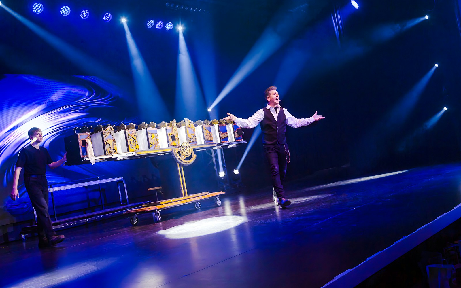 Magician performing on stage during the Evolution Magic Show with dramatic lighting.