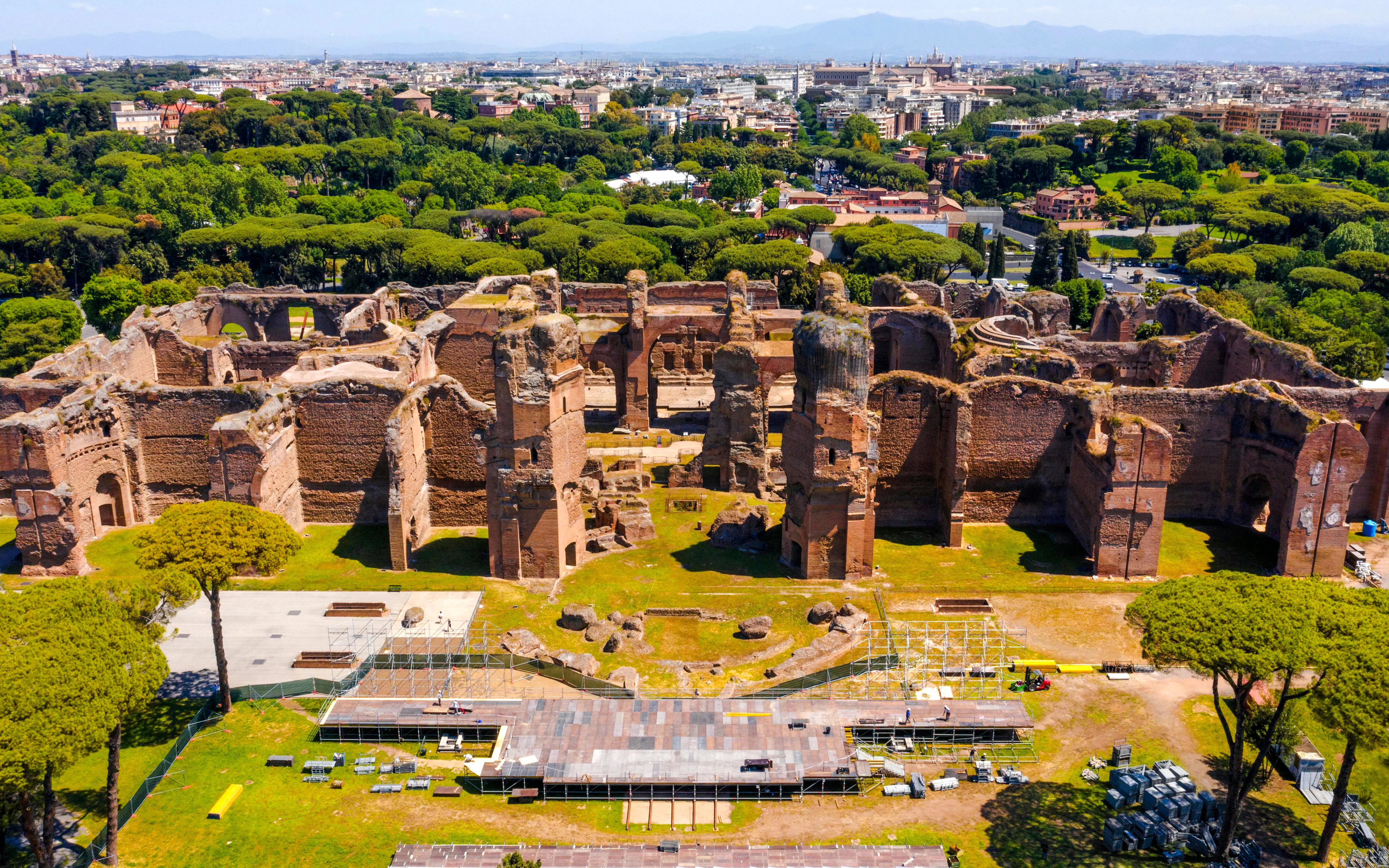 Aerial view of the Baths of Caracalla ruins in Rome, Italy, surrounded by greenery.