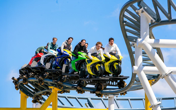Riders on the Motocoaster at Six Flags Darien Lake, experiencing a thrilling ride.