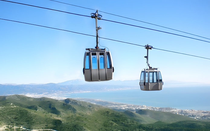 Benalmadena Cable Car over green hills with coastal view in Spain.