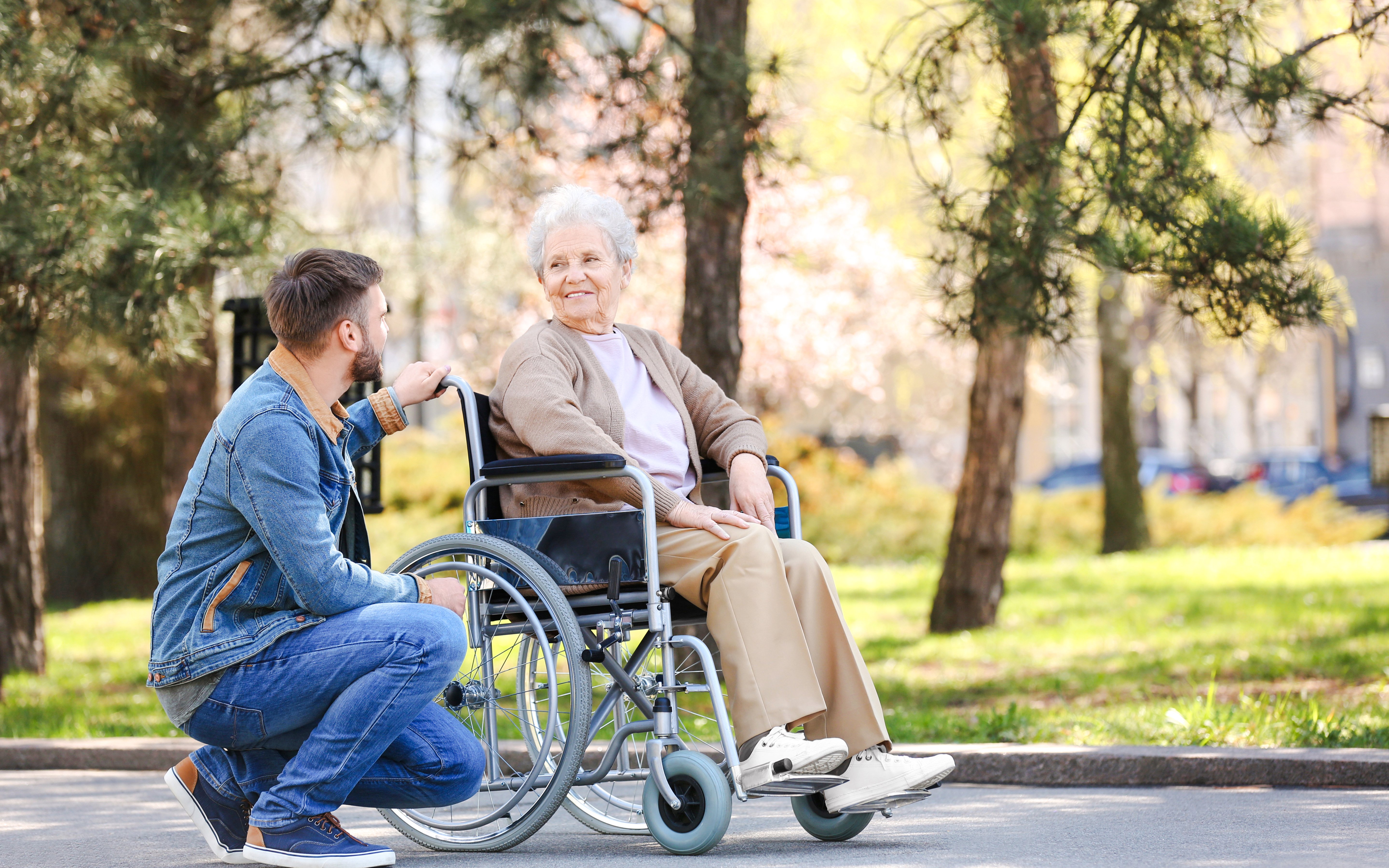 Man and elderly woman in wheelchair enjoying Sigurta Park.