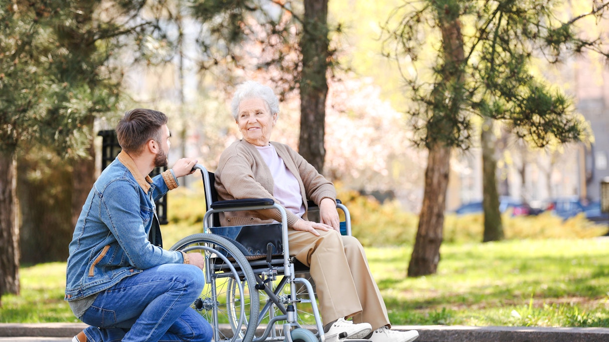 Man and elderly woman in wheelchair enjoying Sigurta Park.