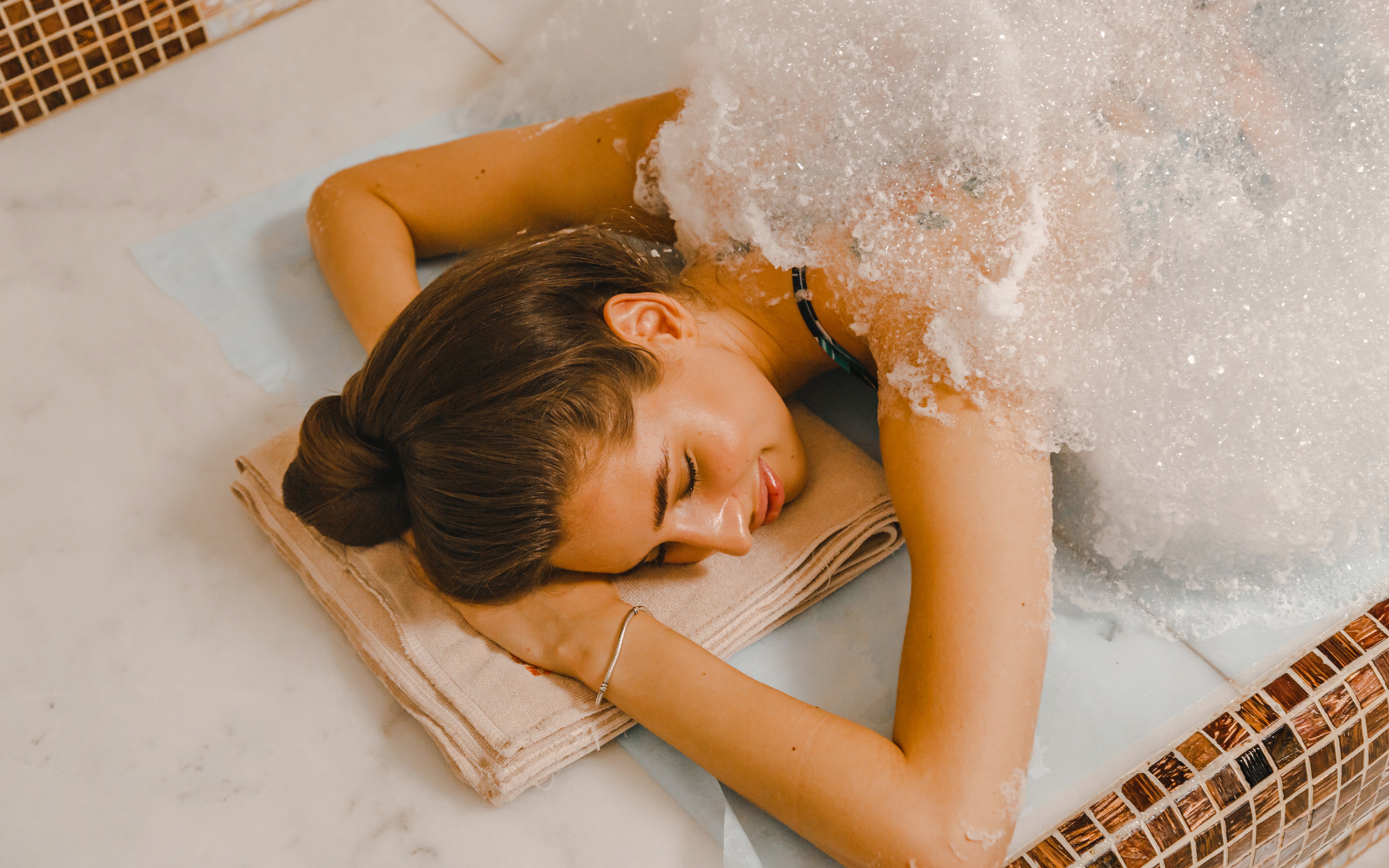 Woman receiving foam massage in a Turkish hammam.