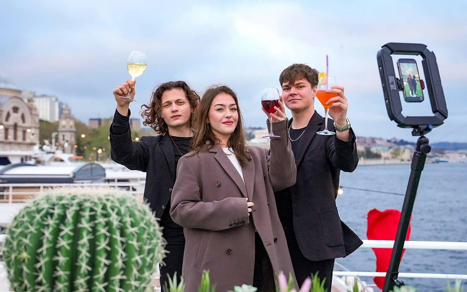 Guests on Bosphorus brunch cruise with private table, enjoying drinks and live music, Istanbul, Turkey.