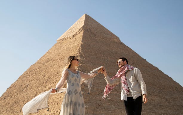 Couple enjoying a private tour in front of the Great Pyramid of Giza, Cairo.