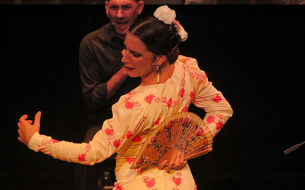 Flamenco dancer with fan performing at Triana Theater.