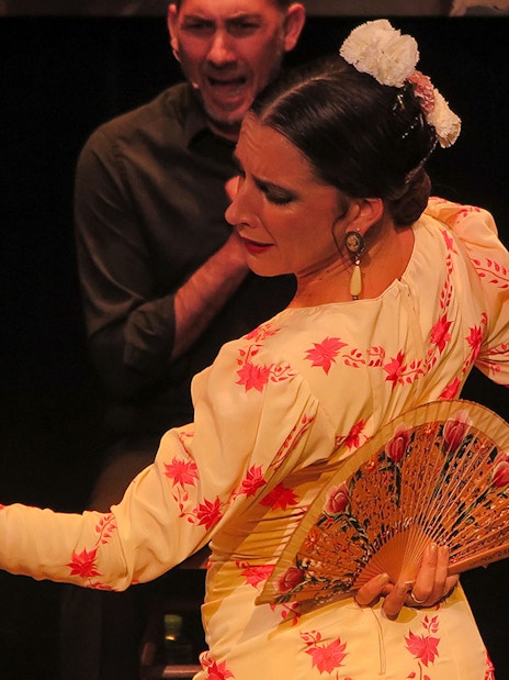 Flamenco dancer with fan performing at Triana Theater.