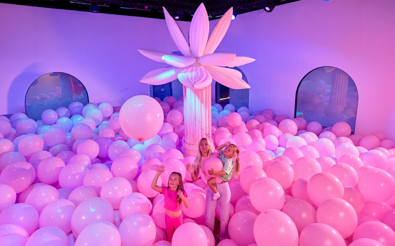 Family enjoying pink balloon room at Bubble Planet Atlanta.