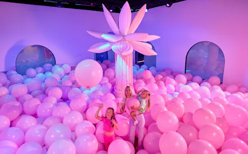 Family enjoying pink balloon room at Bubble Planet Atlanta.