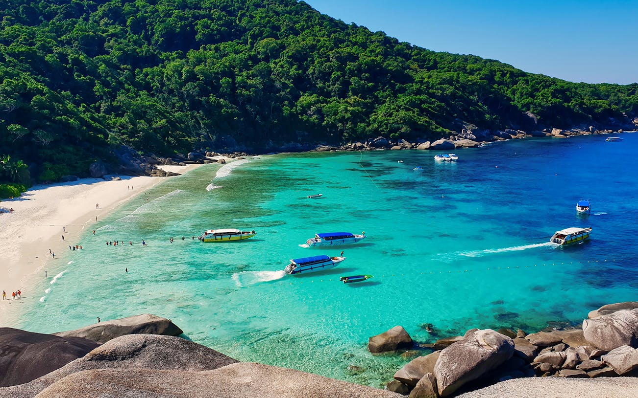 Speed boats and snorkelers in turquoise waters at Similan Islands, Phuket.