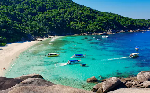 Speed boats and snorkelers in turquoise waters at Similan Islands, Phuket.