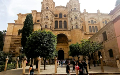 Malaga Cathedral facade with visitors, part of the Malaga Picasso Heist city exploration game.