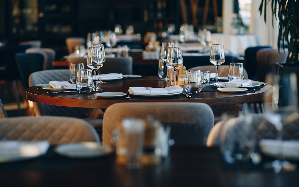 Elegant dining setup at Resorts World Sentosa with neatly arranged tables and glassware.
