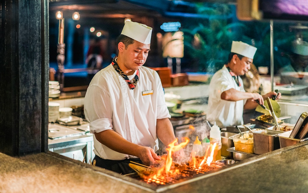 Chefs grilling satay skewers at Ulu Ulu Dinner, Night Safari, Singapore.