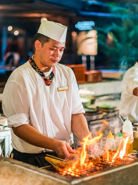 Chefs grilling satay skewers at Ulu Ulu Dinner, Night Safari, Singapore.