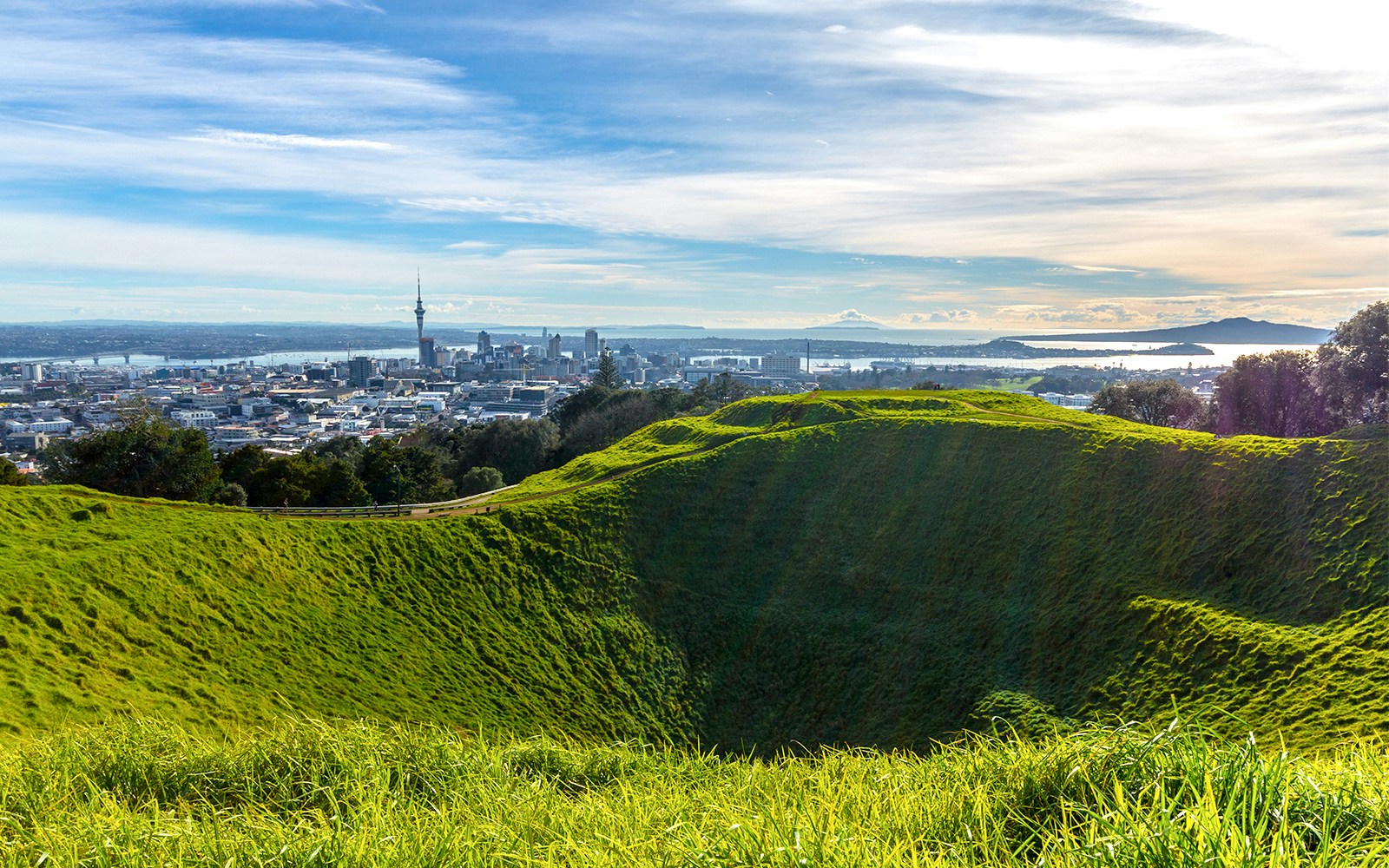 Aerial view of Mt Eden crater with Auckland cityscape in the background.