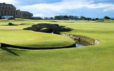 St Andrews golf course with iconic stone bridge and clubhouse in the background, Scotland.