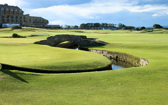 St Andrews golf course with iconic stone bridge and clubhouse in the background, Scotland.