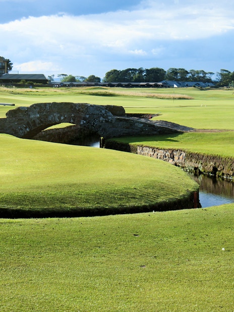 St Andrews golf course with iconic stone bridge and clubhouse in the background, Scotland.