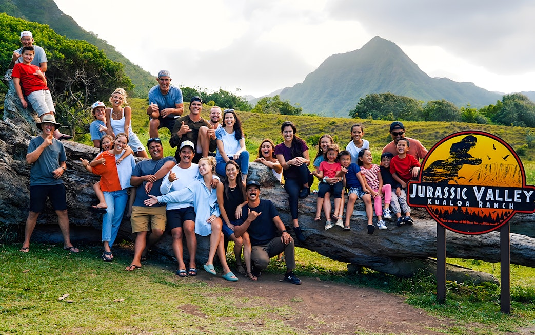 Group enjoying Jurassic Valley at Kualoa Ranch, Hawaii with mountains in the background.