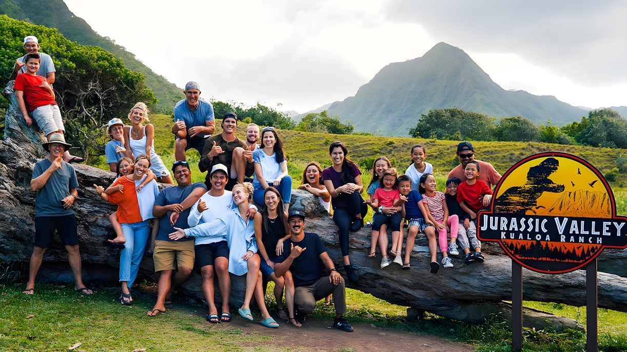 Group enjoying Jurassic Valley at Kualoa Ranch, Hawaii with mountains in the background.