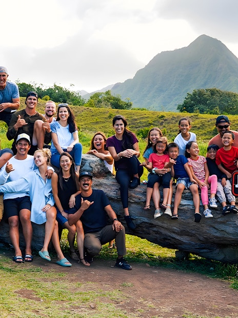Group enjoying Jurassic Valley at Kualoa Ranch, Hawaii with mountains in the background.