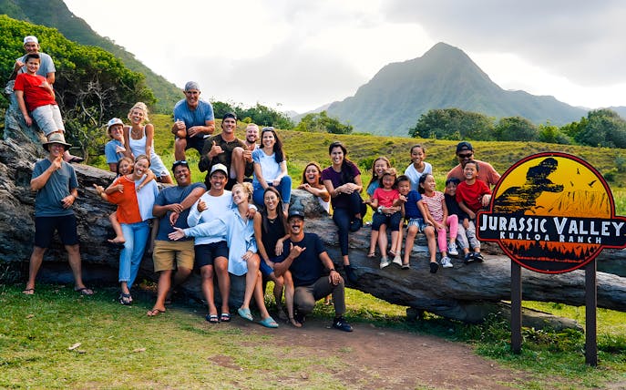 Group enjoying Jurassic Valley at Kualoa Ranch, Hawaii with mountains in the background.