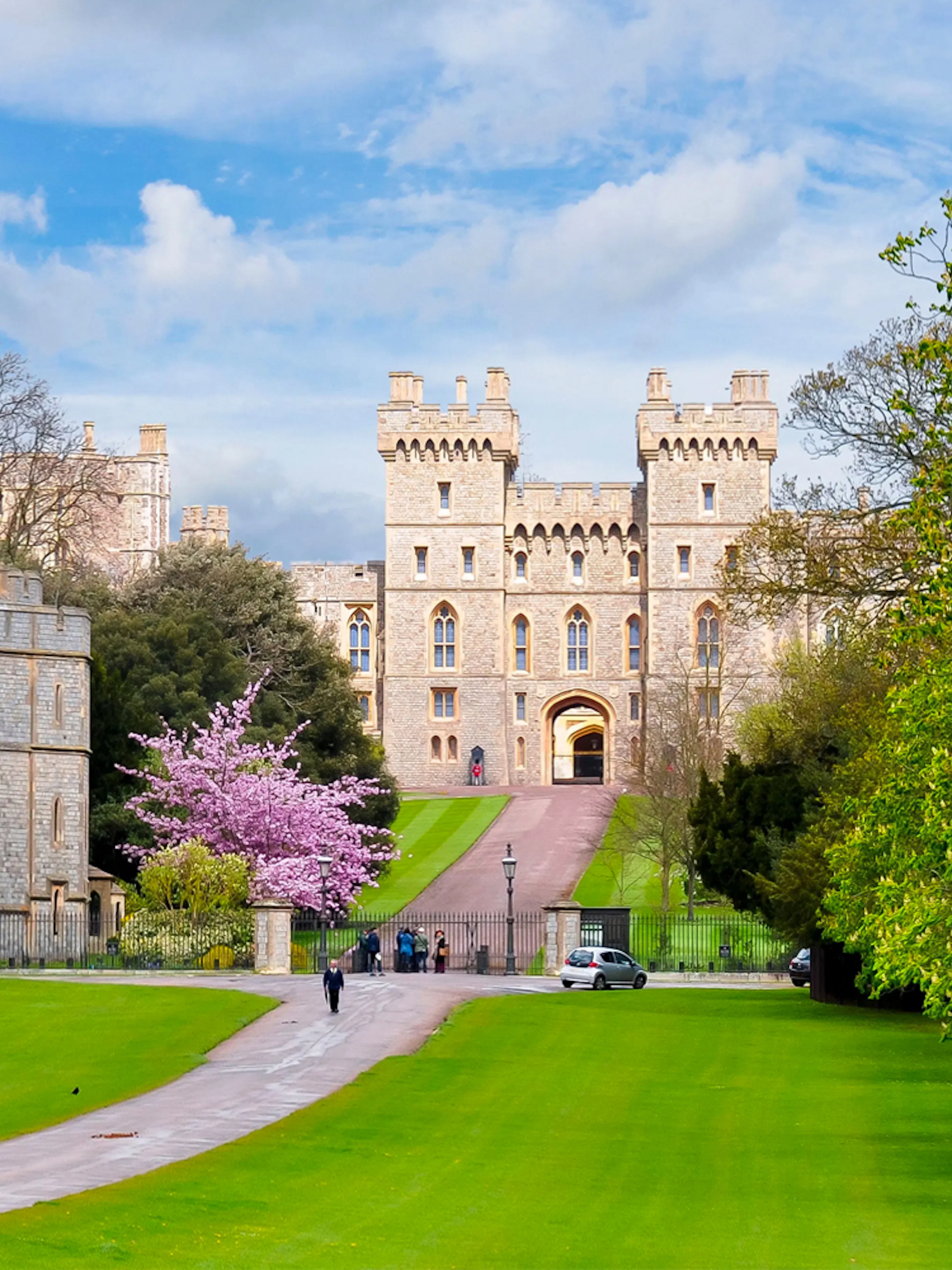 Windsor Castle exterior with lush green lawns and a pathway leading to the entrance.
