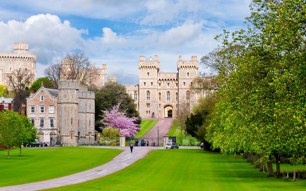 Windsor Castle exterior with lush green lawns and a pathway leading to the entrance.