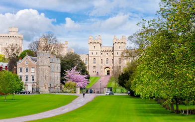 Windsor Castle exterior with lush green lawns and a pathway leading to the entrance.