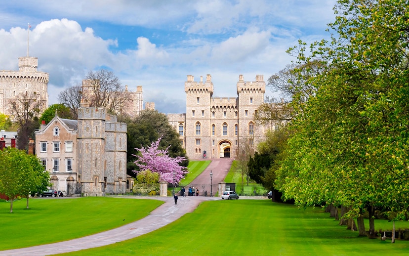 Windsor Castle exterior with lush green lawns and a pathway leading to the entrance.
