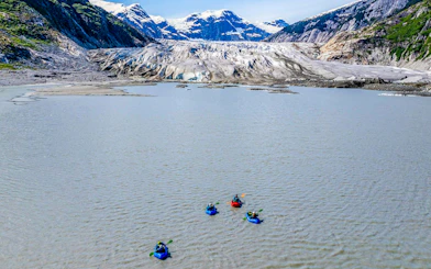 Kayakers paddling towards a glacier in Norris Adventure tour.