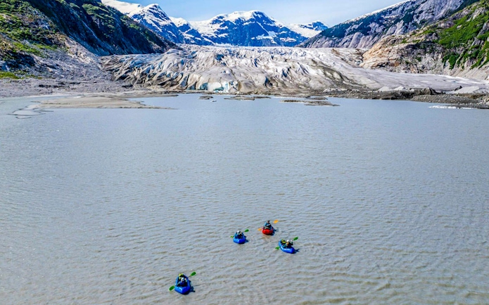 Kayakers paddling towards a glacier in Norris Adventure tour.